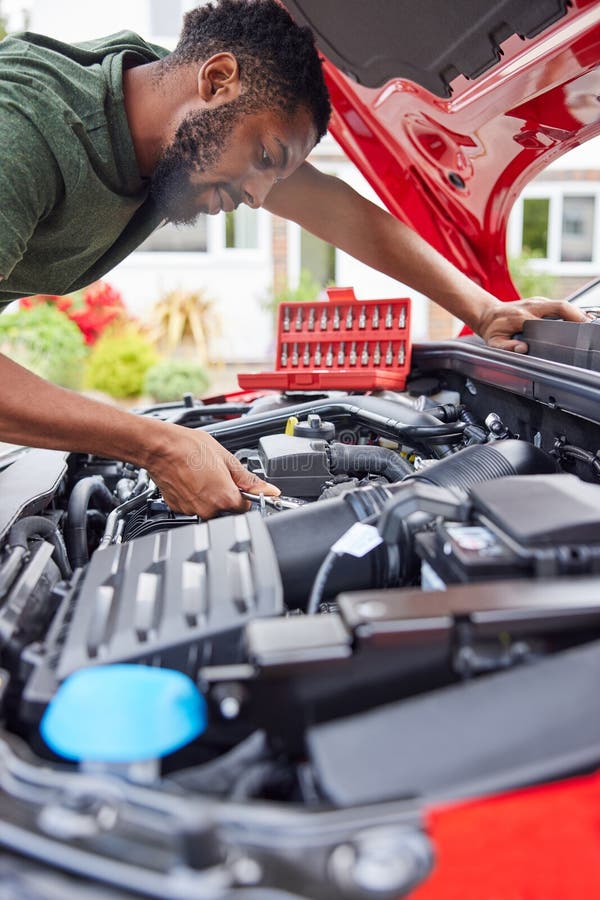 Man Working Under Hood of Car Fixing Engine with Wrench Stock Image