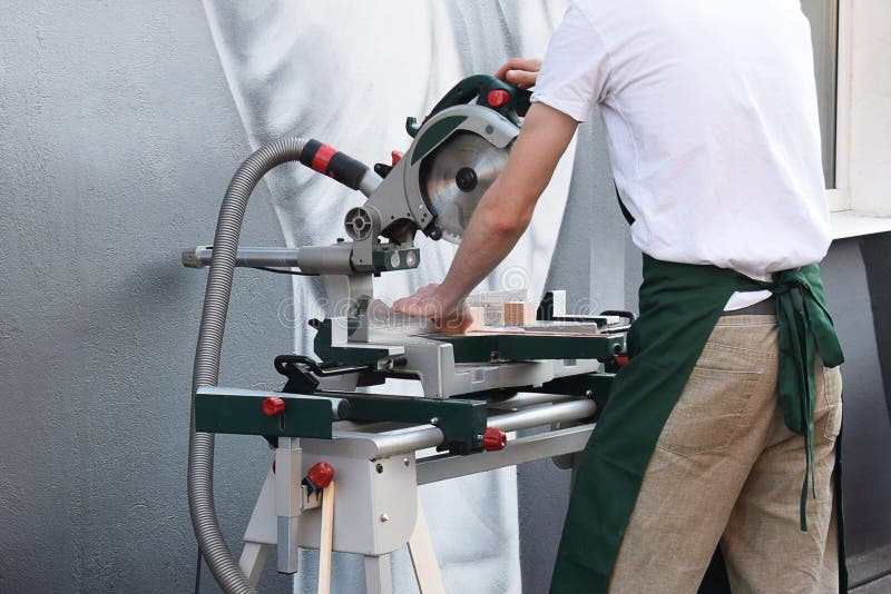 Man working on woodworking machine tool. Carpenter, woodworker using circular saw. Carpenter use circular table electric saw cutting wood. Close-up