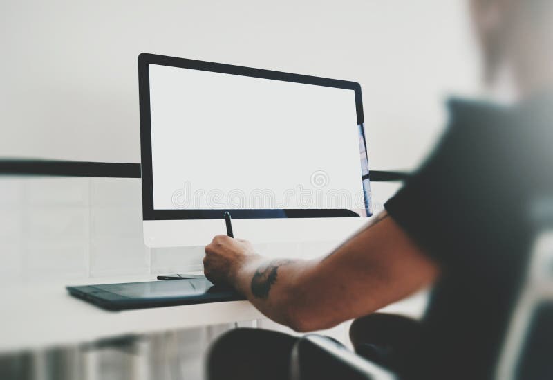 Man working at workspace with generic design computer on the table. Blank screen desktop. Horizontal mockup stock images