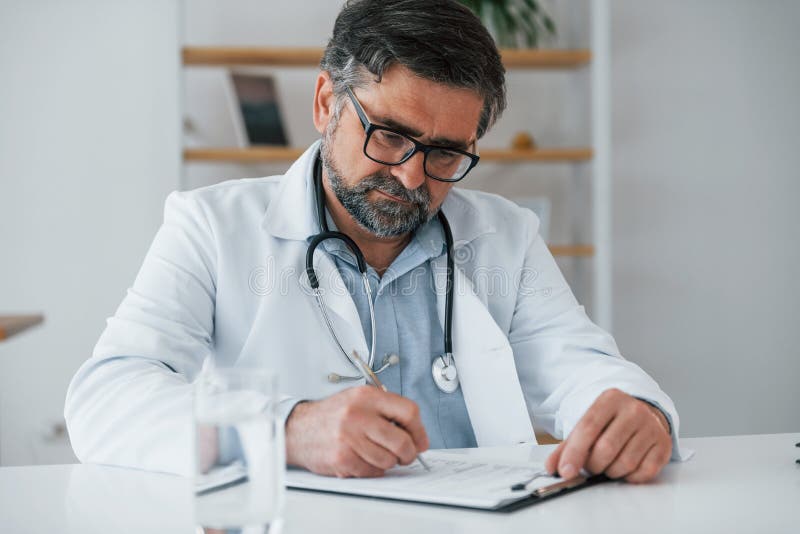 Man Writing Information into the Document. Professional Medical Worker