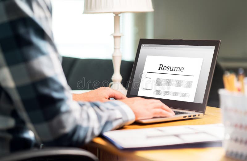 Man writing resume and CV in home office with laptop stock image