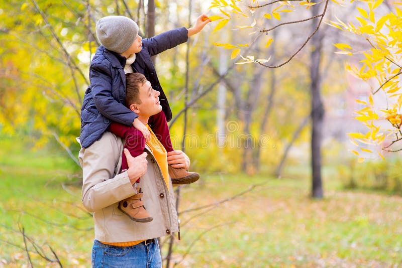 Man With Young Son On Shoulders Autumn Park