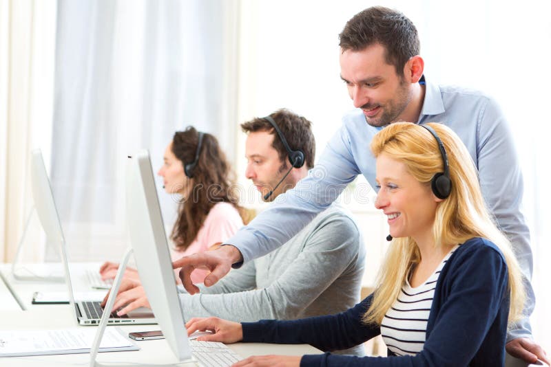 Manager de formare a tinerilor atractivi pe calculator stock photography