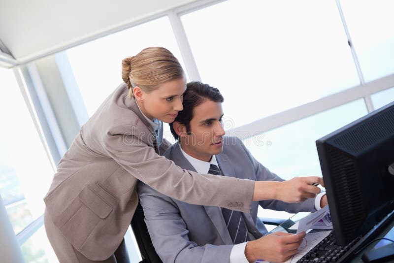 Manager, der auf etwas auf einem Computer zeigt lizenzfreie stockfotografie Manager, der auf etwas auf einem Computer zeigt lizenzfreie stockfotografie