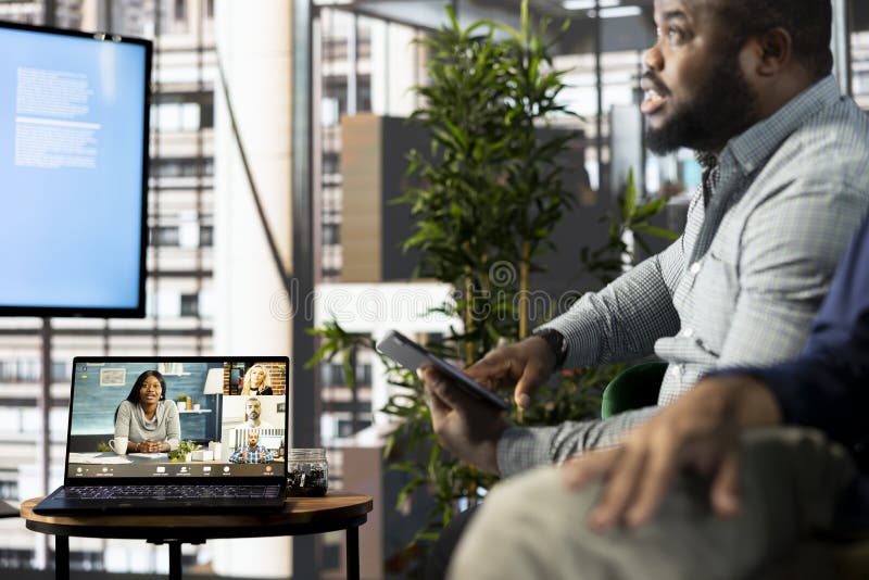 Manager holding online video conference meeting with remotely working workers stock image