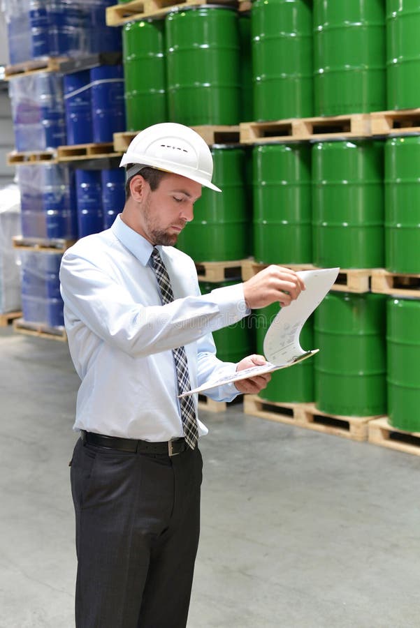 Manager in a logistic company work in a warehouse with chemicals stock photography Manager in a logistic company work in a warehouse with chemicals stock photography