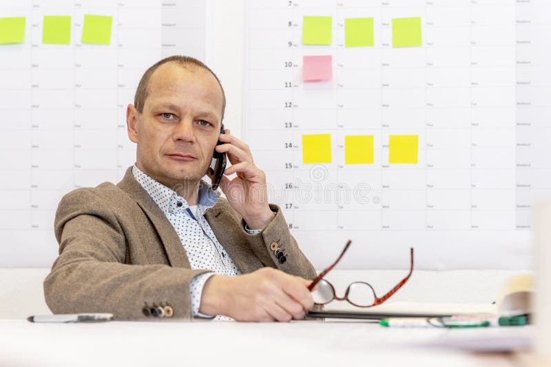 Manager op de telefoon achter een bureau royalty-vrije stock afbeelding Manager op de telefoon achter een bureau royalty-vrije stock afbeelding