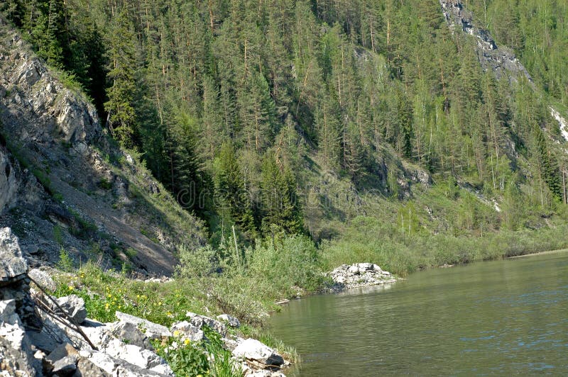 Magnificent landscape. The Siberian mountain river Mana against a mountain taiga, rocks and the sky. Magnificent landscape. The Siberian mountain river Mana against a mountain taiga, rocks and the sky.