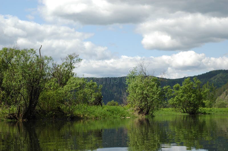 Magnificent landscape. The Siberian mountain river Mana against a mountain taiga and the sky. Magnificent landscape. The Siberian mountain river Mana against a mountain taiga and the sky.