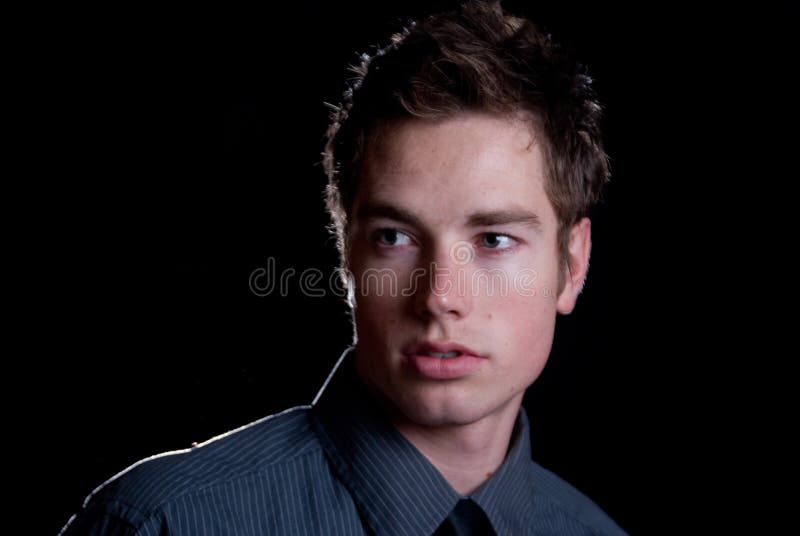 A young male model on a plain background wearing a dress shirt. A young male model on a plain background wearing a dress shirt