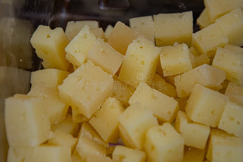 Manchego Cheese Split into Square Pieces for Tasting in the Foreground