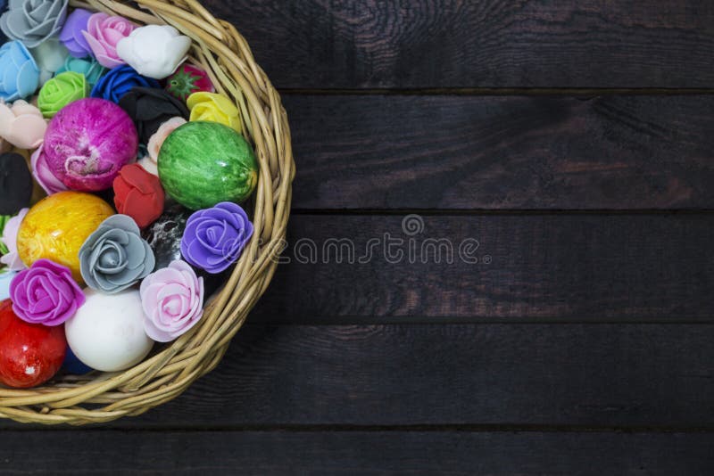 Mand van paaseieren die met document bloemen op donker hout worden verfraaid stock afbeelding Mand van paaseieren die met document bloemen op donker hout worden verfraaid stock afbeelding