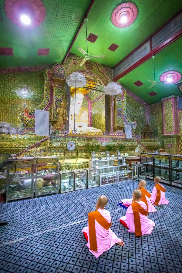 Some Buddhist nuns in prayer kneeling in front of the Buddha. Mandalay, Aungmyaythazan / Myanmar - July 24, 2019: Some Buddhist nuns in prayer kneeling in front stock images Some Buddhist nuns in prayer kneeling in front of the Buddha. Mandalay, Aungmyaythazan / Myanmar - July 24, 2019: Some Buddhist nuns in prayer kneeling in front stock images