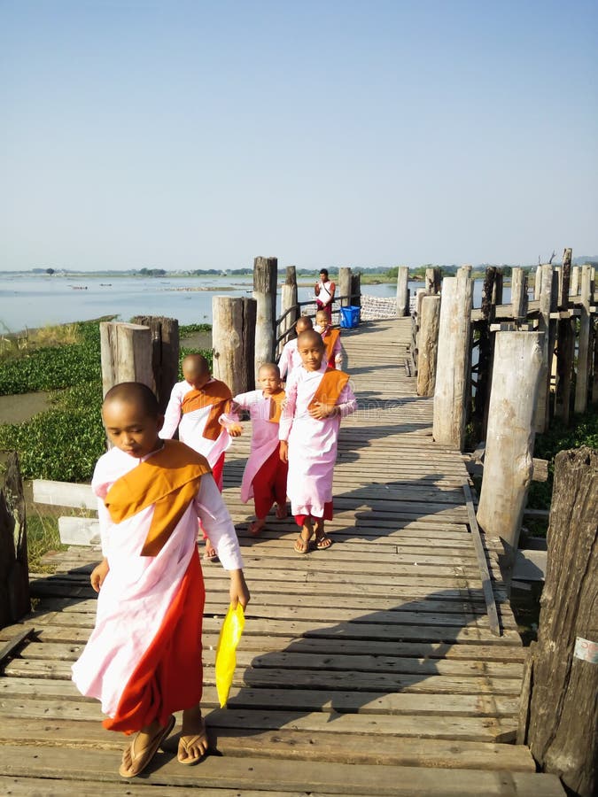 Mandalay, Myanmar - November, 25, 2018 - Buddhist nuns walking on U Bein Bridge in the morning