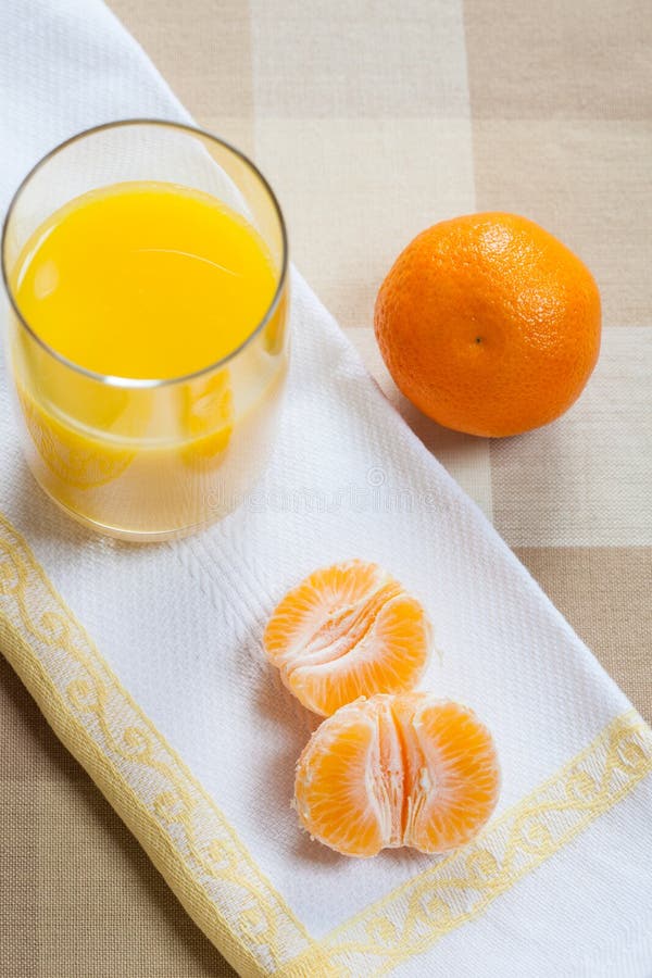 Mandarijntjesegmenten met een glas jus d'orange royalty-vrije stock fotografie Mandarijntjesegmenten met een glas jus d'orange royalty-vrije stock fotografie