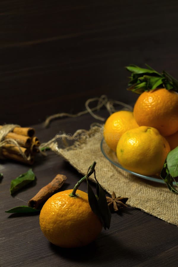 Mandarinas naranjas frescas con hojas verdes en una placa de vidrio sobre un fondo de madera frutas maduras en una mesa oscura te imagen de archivo Mandarinas naranjas frescas con hojas verdes en una placa de vidrio sobre un fondo de madera frutas maduras en una mesa oscura te imagen de archivo