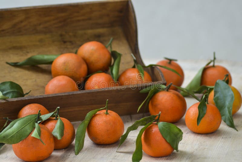 Mandarines fraîches fruit ou mandarines avec des feuilles sur la boîte en bois sur la table image stock Mandarines fraîches fruit ou mandarines avec des feuilles sur la boîte en bois sur la table image stock