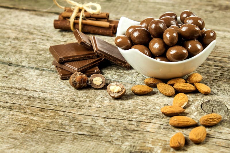 Mandorle nella glassa del cioccolato su una vecchia tavola di legno Alimento non sano Rischio di obesità e di diabete Noci dolci immagine stock libera da diritti Mandorle nella glassa del cioccolato su una vecchia tavola di legno Alimento non sano Rischio di obesità e di diabete Noci dolci immagine stock libera da diritti