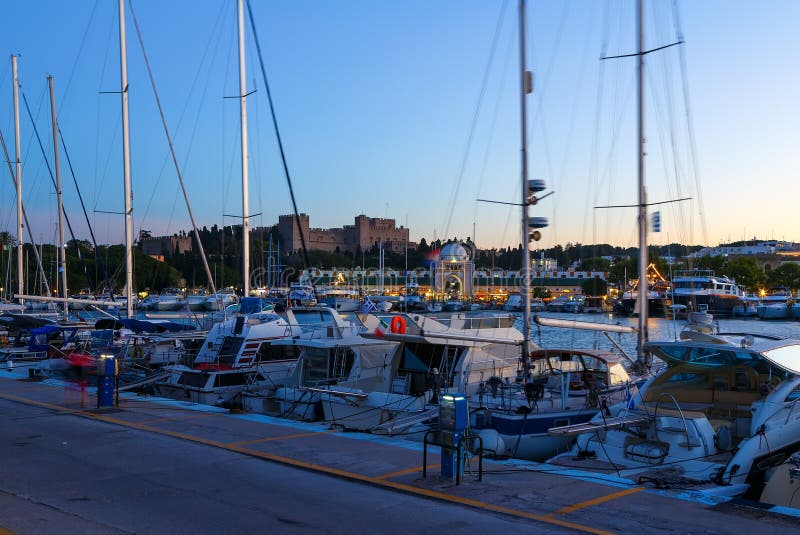 Mandraki-Hafen Rhodes Greece und der Palast des Großmeisters der Ritter von Rhodos nachts lizenzfreie stockbilder Mandraki-Hafen Rhodes Greece und der Palast des Großmeisters der Ritter von Rhodos nachts lizenzfreie stockbilder
