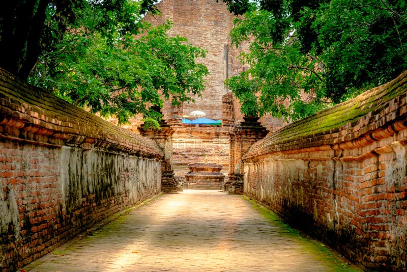 Walk way or entered to old chapel and pagoda with red brick wall of Wat Maheyong temple , Ayutthaya historical park Thailand. Vintage photo effect. Walk way or entered to old chapel and pagoda with red brick wall of Wat Maheyong temple , Ayutthaya historical park Thailand. Vintage photo effect.