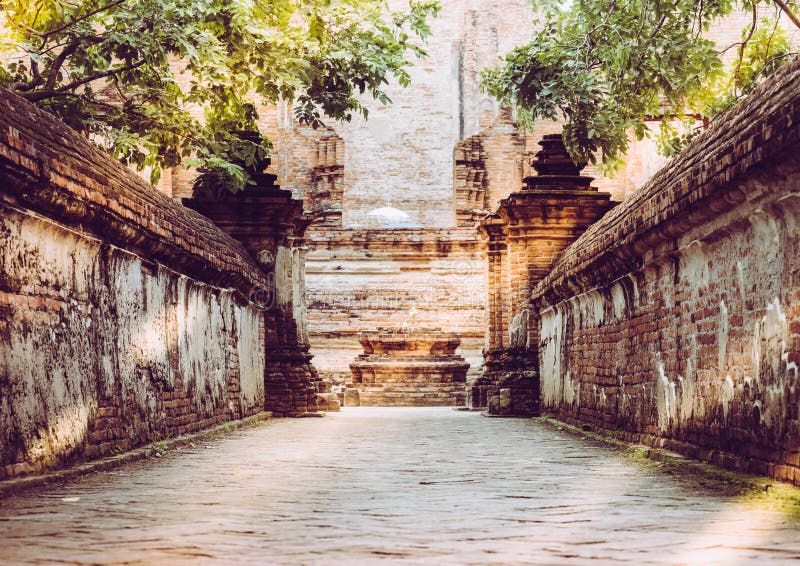 Walk way or entered to old chapel and pagoda with red brick wall of Wat Maheyong temple , Ayutthaya historical park Thailand. Vintage photo effect. Walk way or entered to old chapel and pagoda with red brick wall of Wat Maheyong temple , Ayutthaya historical park Thailand. Vintage photo effect.