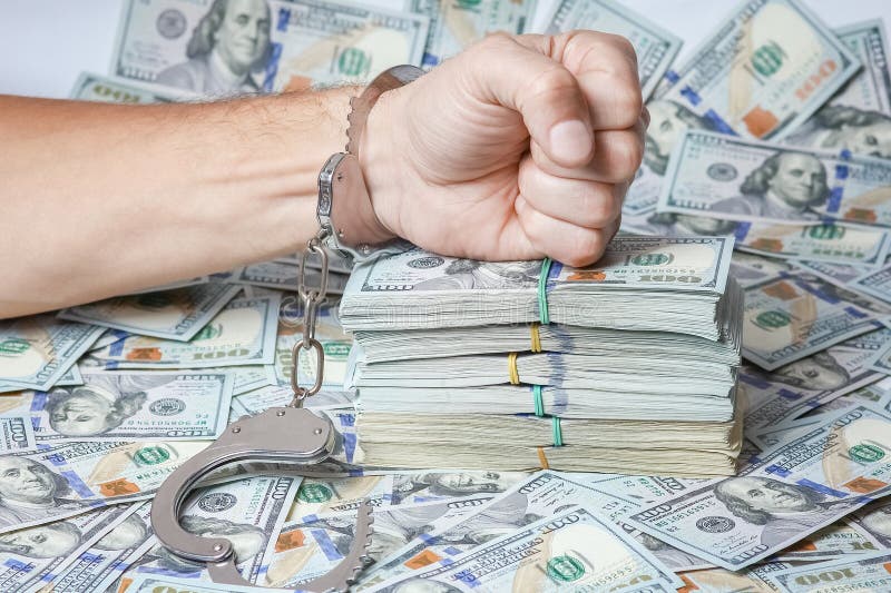 hands in handcuffs real estate business danger with dollars in pondemic concept. hands in handcuffs real estate business danger with dollars in pondemic concept