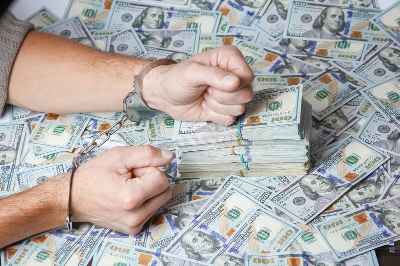 hands in handcuffs real estate business danger with dollars in pondemic concept. hands in handcuffs real estate business danger with dollars in pondemic concept