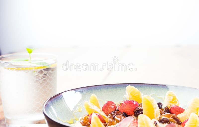 Mangi la farina d'avena sana e nutriente ben- della prima colazione, la frutta, il miele, l'acqua fotografie stock libere da diritti Mangi la farina d'avena sana e nutriente ben- della prima colazione, la frutta, il miele, l'acqua fotografie stock libere da diritti