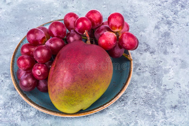 Mango i winogrona na talerzu fotografia royalty free Mango i winogrona na talerzu fotografia royalty free