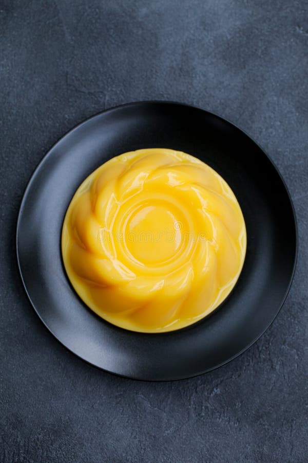 Mango pudding, jelly, dessert on black plate. Slate background. Top view. royalty free stock image Mango pudding, jelly, dessert on black plate. Slate background. Top view. royalty free stock image