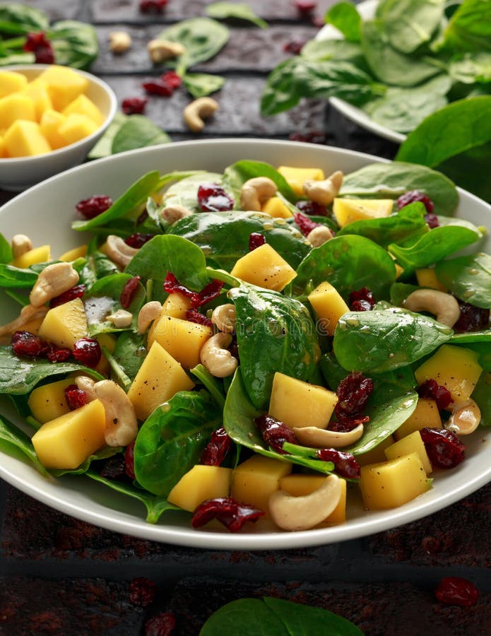 Mango Spinach Salad with Dried Cranberries and Nuts. Healthy Food
