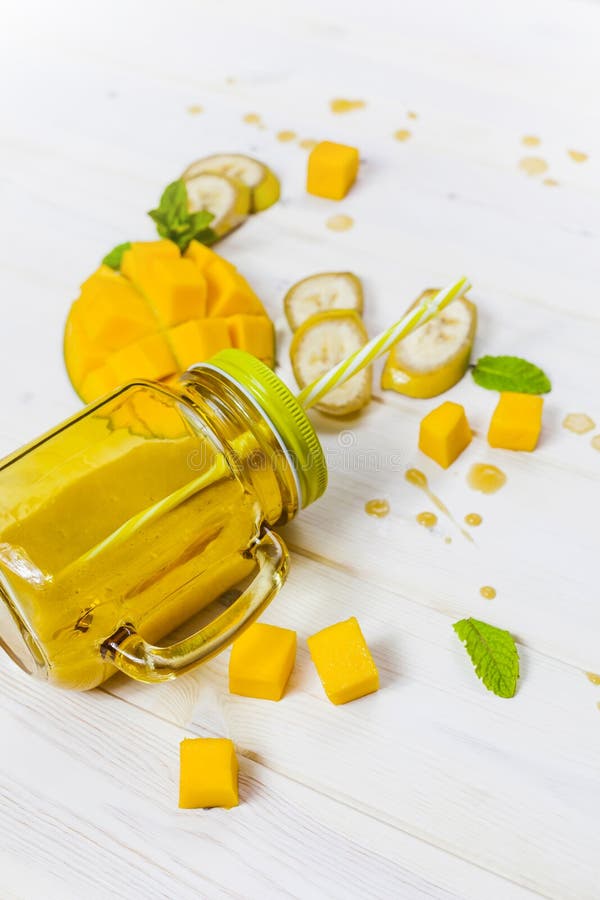 Mango und Banane Smoothie im Weckglas mit Stroh lizenzfreie stockfotografie Mango und Banane Smoothie im Weckglas mit Stroh lizenzfreie stockfotografie
