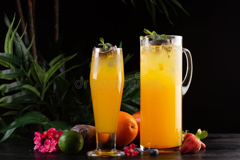 Mangolimonade - passievrucht in een kruik en een glas en fruit op een houten achtergrond royalty-vrije stock afbeelding Mangolimonade - passievrucht in een kruik en een glas en fruit op een houten achtergrond royalty-vrije stock afbeelding