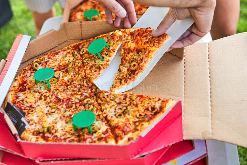 Manhand som rymmer en skiva av delicous pizza arkivfoto Manhand som rymmer en skiva av delicous pizza arkivfoto