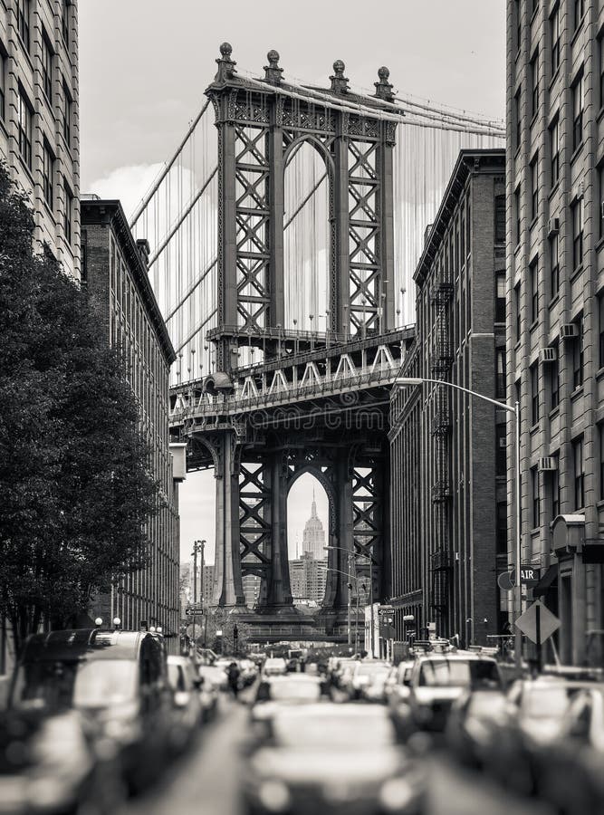 Manhattan Bridge and Empire State Building seen from Brooklyn, New York. Black and white image with a blurred foreground. Manhattan Bridge and Empire State Building seen from Brooklyn, New York. Black and white image with a blurred foreground