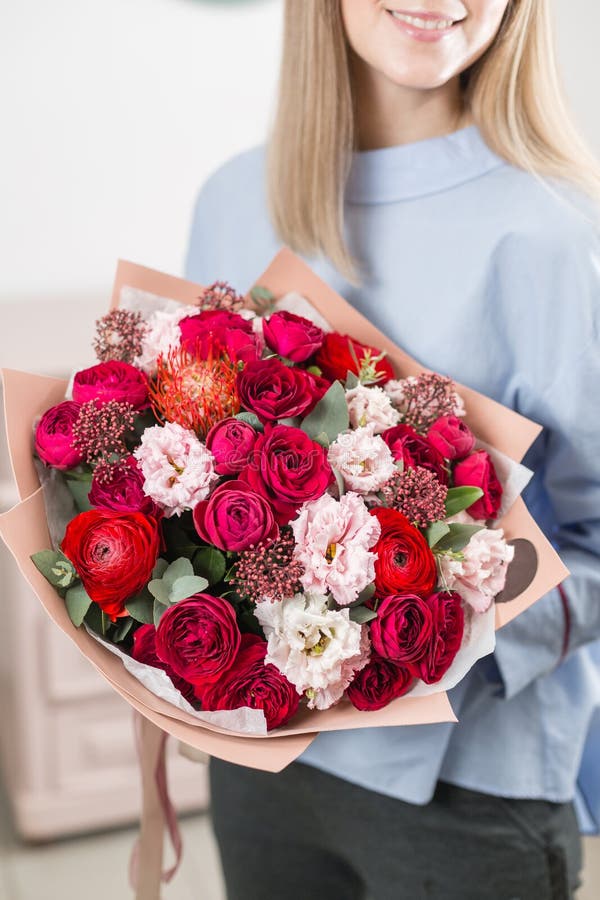 Manhã ensolarada da mola Mulher feliz nova que guarda um ramalhete luxuoso bonito de flores misturadas o trabalho do florista em imagem de stock Manhã ensolarada da mola Mulher feliz nova que guarda um ramalhete luxuoso bonito de flores misturadas o trabalho do florista em imagem de stock