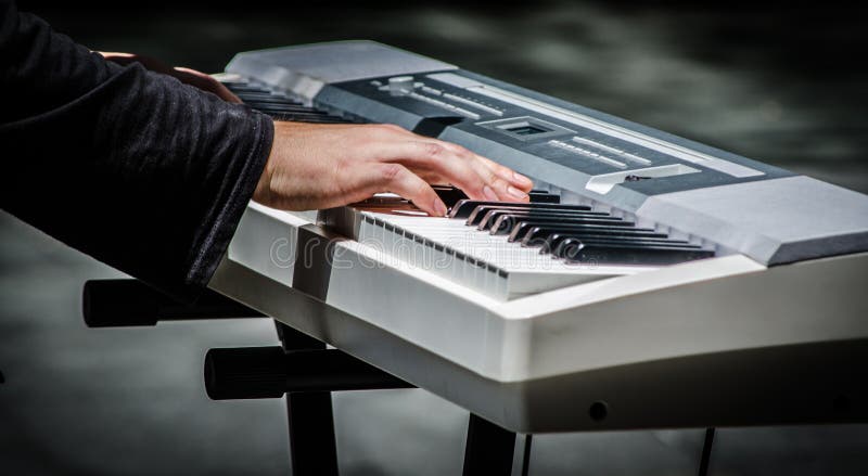 Manhänder som spelar tangentbordpianot, är ett elektroniskt musikinstrument royaltyfria bilder Manhänder som spelar tangentbordpianot, är ett elektroniskt musikinstrument royaltyfria bilder