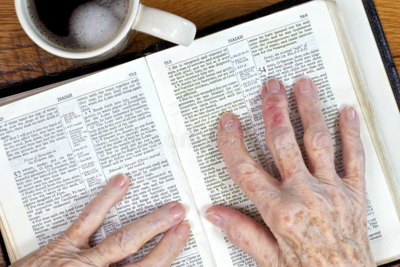 Elderly woman’s arthritic hands holding her hebrew language bible as she reads from Isaiah 53. Elderly woman’s arthritic hands holding her hebrew language bible as she reads from Isaiah 53.