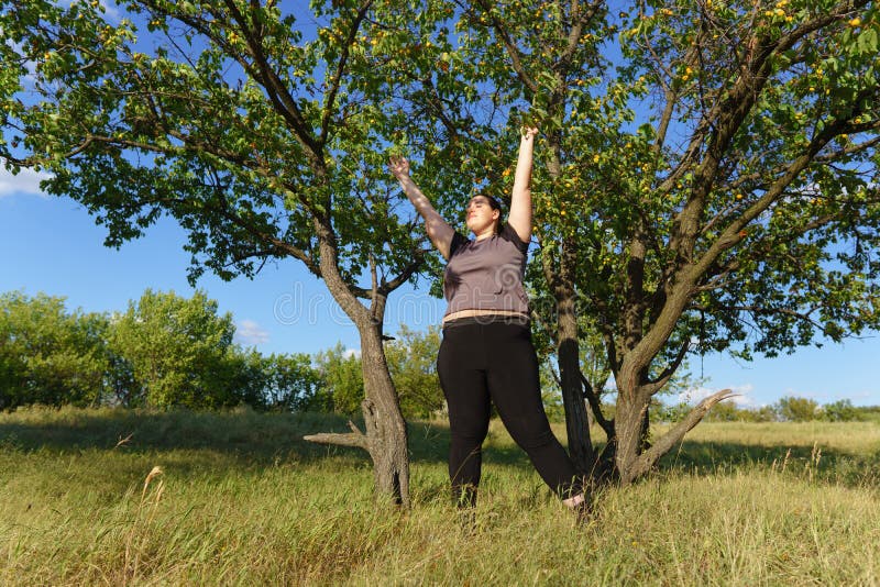 Mani in aumento della donna di peso eccessivo verso il cielo fotografia stock libera da diritti Mani in aumento della donna di peso eccessivo verso il cielo fotografia stock libera da diritti
