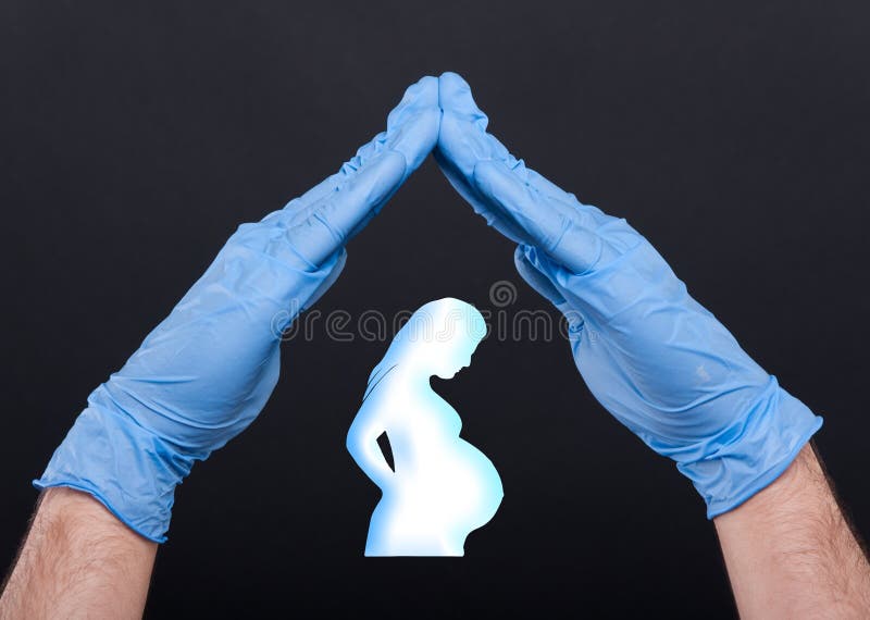 Mani che proteggono siluetta di una donna incinta fotografia stock Mani che proteggono siluetta di una donna incinta fotografia stock