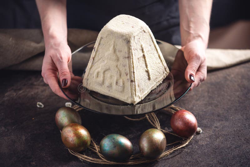 Mani che tengono i dessert tradizionali e le uova variopinte nello stile rustico su un fondo scuro Pasqua felice immagini stock libere da diritti Mani che tengono i dessert tradizionali e le uova variopinte nello stile rustico su un fondo scuro Pasqua felice immagini stock libere da diritti
