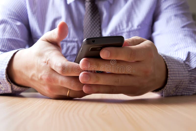 Mani che tengono uno smartphone fotografia stock libera da diritti