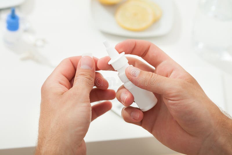 Cropped image of hands holding nasal drop bottle at home. Cropped image of hands holding nasal drop bottle at home