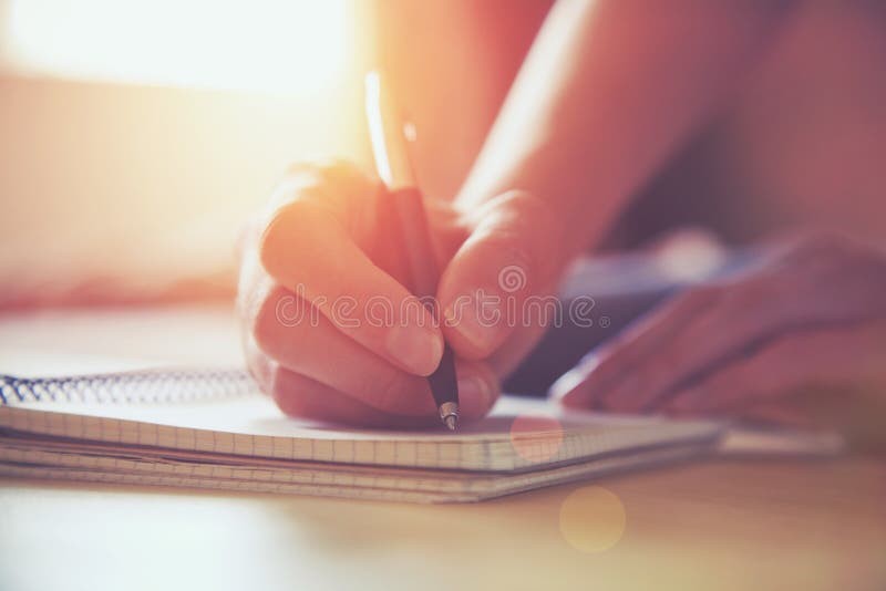 Mani con scrittura della penna sul taccuino