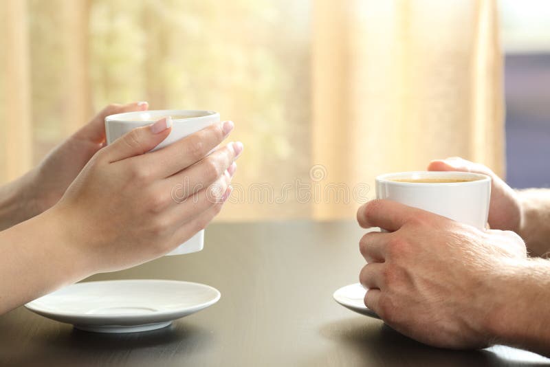 Mani degli amici o delle coppie che tengono le tazze di caffè immagini stock Mani degli amici o delle coppie che tengono le tazze di caffè immagini stock
