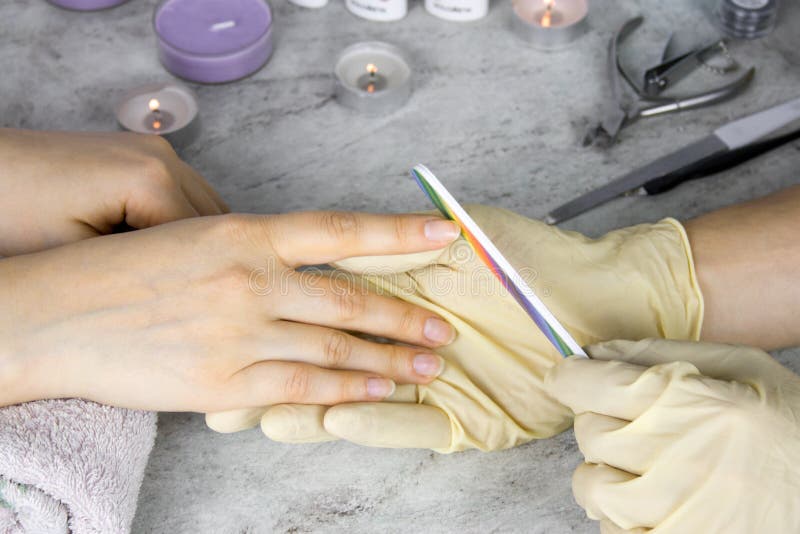 mani del manicure in guanti con tenersi per mano dell'archivio di unghia del cliente, del processo del manicure e della cura dell fotografia stock mani del manicure in guanti con tenersi per mano dell'archivio di unghia del cliente, del processo del manicure e della cura dell fotografia stock