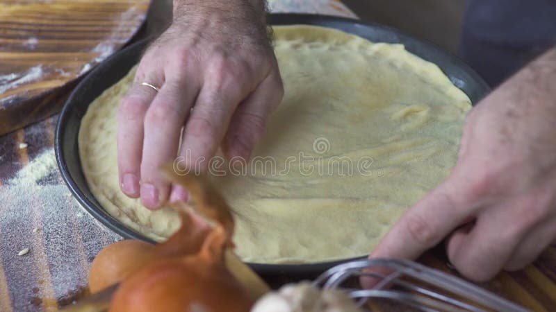 Mani del panettiere che mettono pasta per la torta nella fine bollente del vassoio su Creatore della pizza che produce pasta per