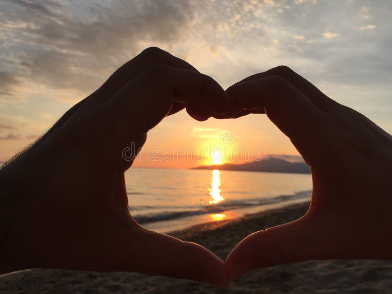 Mani dell'Italia della spiaggia di amore di tramonto fotografia stock Mani dell'Italia della spiaggia di amore di tramonto fotografia stock
