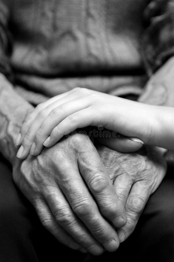 Mani dell'uomo anziano e di una giovane donna immagini stock libere da diritti Mani dell'uomo anziano e di una giovane donna immagini stock libere da diritti