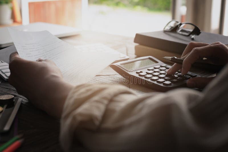 Mani dell'uomo di affari che tengono il libretto di banca di conto di risparmio con il calcolatore, conto e conservanti concetto fotografia stock Mani dell'uomo di affari che tengono il libretto di banca di conto di risparmio con il calcolatore, conto e conservanti concetto fotografia stock